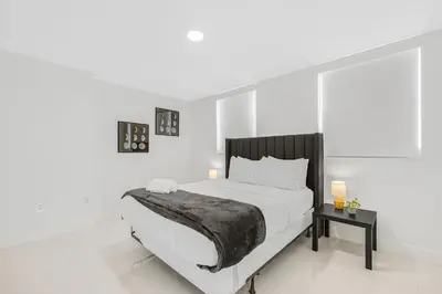a white bedroom with a large bed and a table at Modern Brickell Condo with Prime City Views in Miami