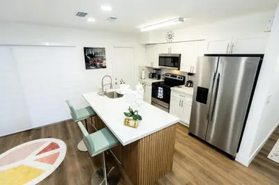 a kitchen with a refrigerator and a table with chairs at Your Perfect Oasis in Miami! in Miami
