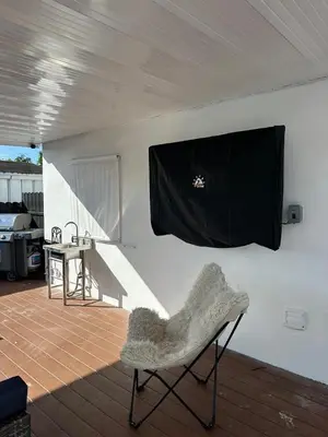 a living room with a chair and a television on a wall at Your Perfect Oasis in Miami! in Miami