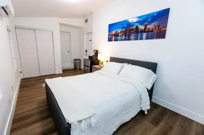 a bedroom with a white bed and a painting on the wall at Best Room in Miami ! in Miami