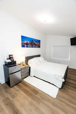 a white bedroom with a bed and a night stand at Best Room in Miami ! in Miami