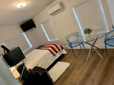 a bedroom with a bed and a table and a television at Best Room in Miami ! in Miami