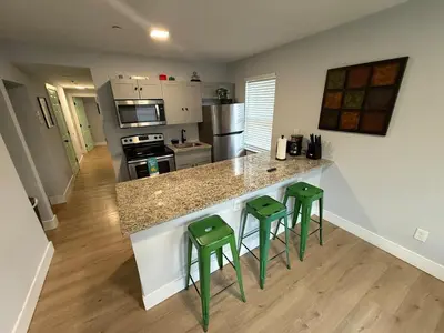 a kitchen with two green stools at a counter at Prime Location Near Wynwood in Miami