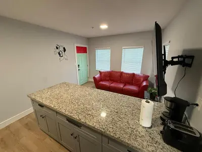 a kitchen with a counter and a red couch in a room at Perfect Central Stay in Miami