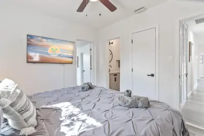 a white bedroom with a large bed and a ceiling fan at Near Beach Family Escape Heated Pool Fire Pit BBQ in Hallandale Beach