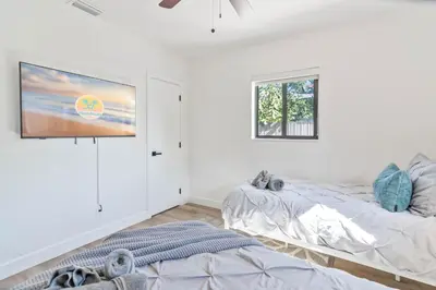 a bedroom with two beds and a flat screen tv at Near Beach Family Escape Heated Pool Fire Pit BBQ in Hallandale Beach