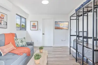 a living room with a couch and a stair case at Near Beach Family Escape Heated Pool Fire Pit BBQ in Hallandale Beach