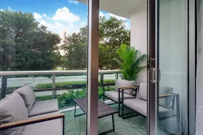 a balcony with two chairs and a table at Beachfront Oasis in Sunny Isles 3BR, Pool & Tennis in Sunny Isles Beach