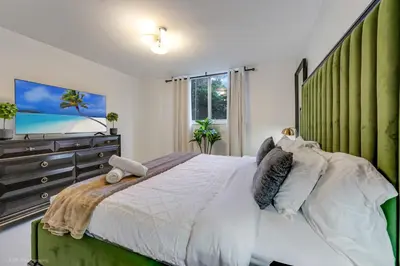 a bedroom with a large bed and a dresser at Beachfront Oasis in Sunny Isles 3BR, Pool & Tennis in Sunny Isles Beach