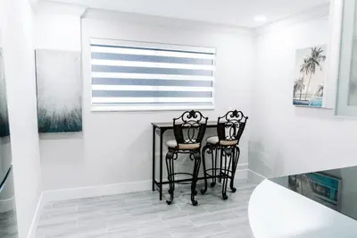 a dining room with two black chairs and a table at Welcome to 305 Rentals in Miami Gardens