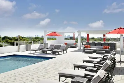 a patio with lounge chairs and a swimming pool at Four Points by Sheraton Coral Gables in Miami