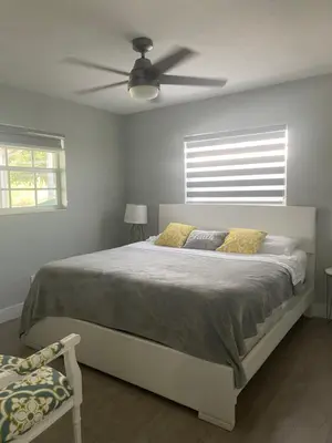a bedroom with a bed with a ceiling fan at Gardens Get Away in Pembroke Pines