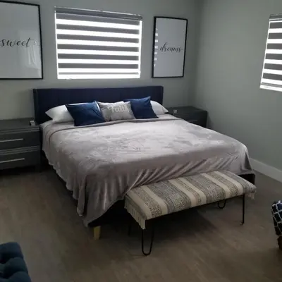 a bedroom with a large bed and two windows at Gardens Get Away in Pembroke Pines