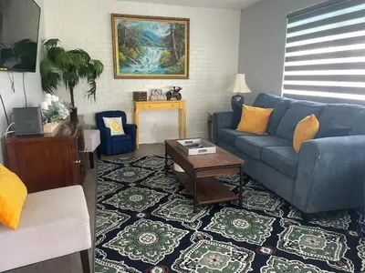 a living room with a blue couch and a table at Gardens Get Away in Pembroke Pines