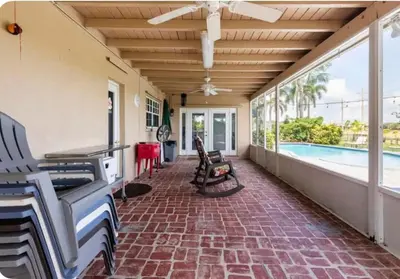 a screened in porch with a piano and a pool at Gardens Get Away in Pembroke Pines