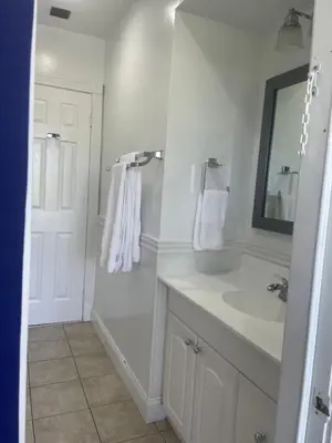 a white bathroom with a sink and a mirror at Gardens Get Away in Pembroke Pines