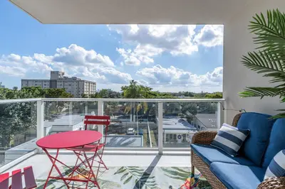 a balcony with a blue couch and a red table at Resort-Style 1 Bed Condo with Pool Parking Rooftop & Gym in Hollywood