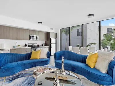 a living room with blue couches and a kitchen at X Lounge III-Modern Corner Residence in Miami