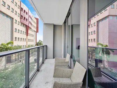 a balcony with chairs and windows in a building at X Lounge III-Modern Corner Residence in Miami