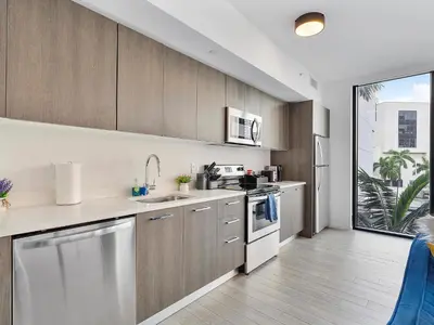 a kitchen with wooden cabinets and stainless steel appliances at X Lounge III-Modern Corner Residence in Miami