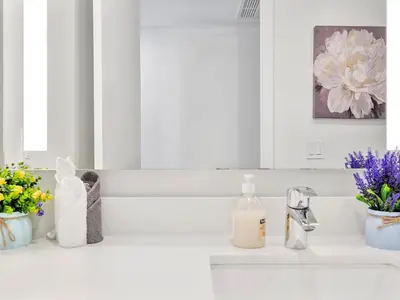a white bathroom with flowers and a sink at X Lounge III-Modern Corner Residence in Miami