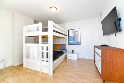 a white bunk bed in a room with a tv at Condo That Will Make Feel the Ocean Breeze Close in Miami