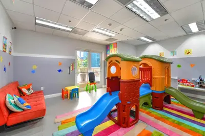 a childrens play room with a slide and a couch at Condo That Will Make Feel the Ocean Breeze Close in Miami