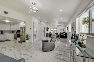 a large living room with marble floors and a kitchen at Luxurious Tropical Private Oasis by Mia Airport in Hialeah