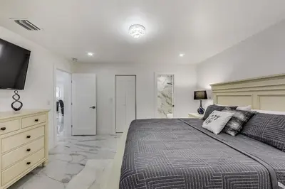 a bedroom with a large bed and a television at Luxurious Tropical Private Oasis by Mia Airport in Hialeah
