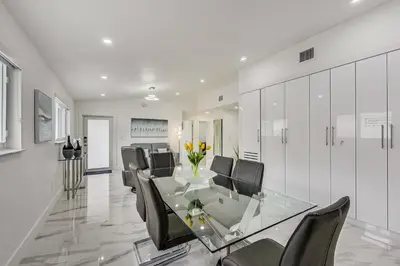 a dining room with a glass table and black chairs at Luxurious Tropical Private Oasis by Mia Airport in Hialeah