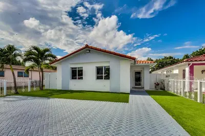 a white house with a fence and grass at Luxurious Tropical Private Oasis by Mia Airport in Hialeah