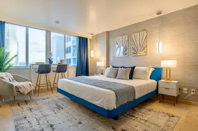 a hotel room with a bed and a table and chairs at Stunning Beachfront condo in sunny Sunny Isles Beach with AC, fitness room, WiFi in Sunny Isles Beach
