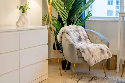a chair with a blanket on it next to a dresser at Stunning Beachfront condo in sunny Sunny Isles Beach with AC, fitness room, WiFi in Sunny Isles Beach