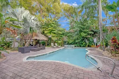 a swimming pool with a brick walkway around it at Tropical Oasis Studio w Pool in Fort Lauderdale
