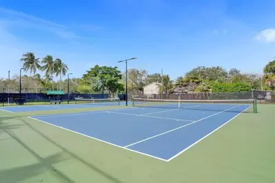 a tennis court with two tennis courts at Tropical Oasis Studio w Pool in Fort Lauderdale