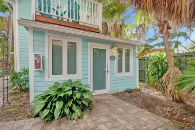 a blue house with a balcony on top of it at Tropical Oasis Studio w Pool in Fort Lauderdale