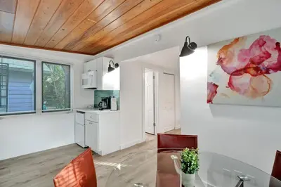 a kitchen with a dining table and a painting on the wall at Tropical Oasis Studio w Pool in Fort Lauderdale