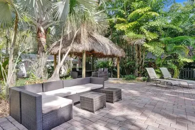 a patio with a couch and chairs and trees at Tropical Oasis Studio w Pool in Fort Lauderdale