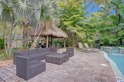a patio with a table and chairs next to a pool at Tropical Oasis Studio w Pool in Fort Lauderdale