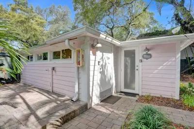 a white house with a garage and a driveway at Tropical Oasis Studio w Pool in Fort Lauderdale