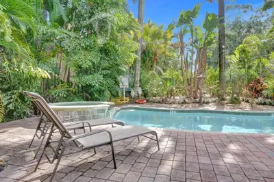 a chair sitting in front of a swimming pool at Tropical Oasis Studio w Pool in Fort Lauderdale