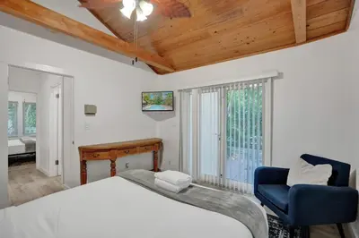 a bedroom with a bed and a chair and a window at Tropical Oasis 2BR House w Pool in Fort Lauderdale