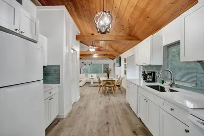 a kitchen with white cabinets and a wooden ceiling at Tropical Oasis 2BR House w Pool in Fort Lauderdale