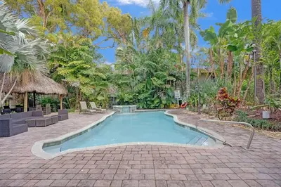a swimming pool in the middle of a courtyard with trees at Tropical Oasis 2BR House w Pool in Fort Lauderdale