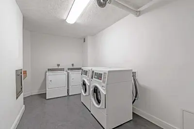 a laundry room with three washing machines and a washer and dryer at Stylish Ocean Apartment with Pool in Hollywood