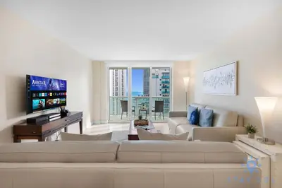 a living room with a couch and a tv at Stylish Ocean Apartment with Pool in Hollywood