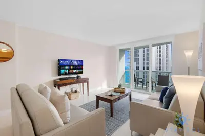 a living room with a couch and a tv at Stylish Ocean Apartment with Pool in Hollywood