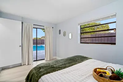 a bedroom with a bed and a large window at Las Olas Fort Lauderdale Getaway Pool, BBQ, Mini Golf & Game Room in Fort Lauderdale