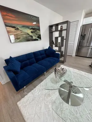 a living room with a blue couch and a glass table at Modern Apartment Miami Oasis in Miami