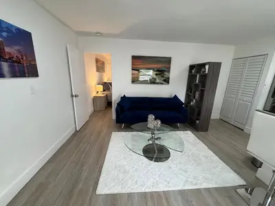 a living room with a blue couch and a table at Modern Apartment Miami Oasis in Miami
